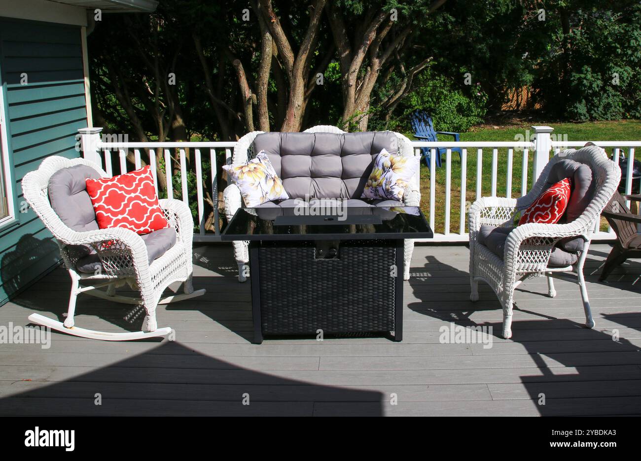 Une terrasse confortable dispose d'un coin salon rembourré avec des oreillers décoratifs et une table élégante. Banque D'Images