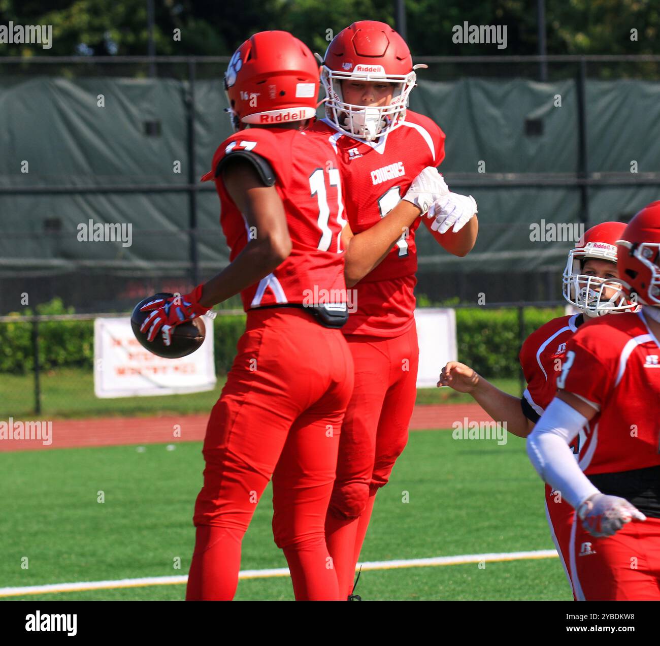 West Islip, New York, États-Unis - 14 septembre 2024 : deux footballeurs de lycée sautent en l'air et se mettent à la poitrine pour célébrer le touchdown. Banque D'Images