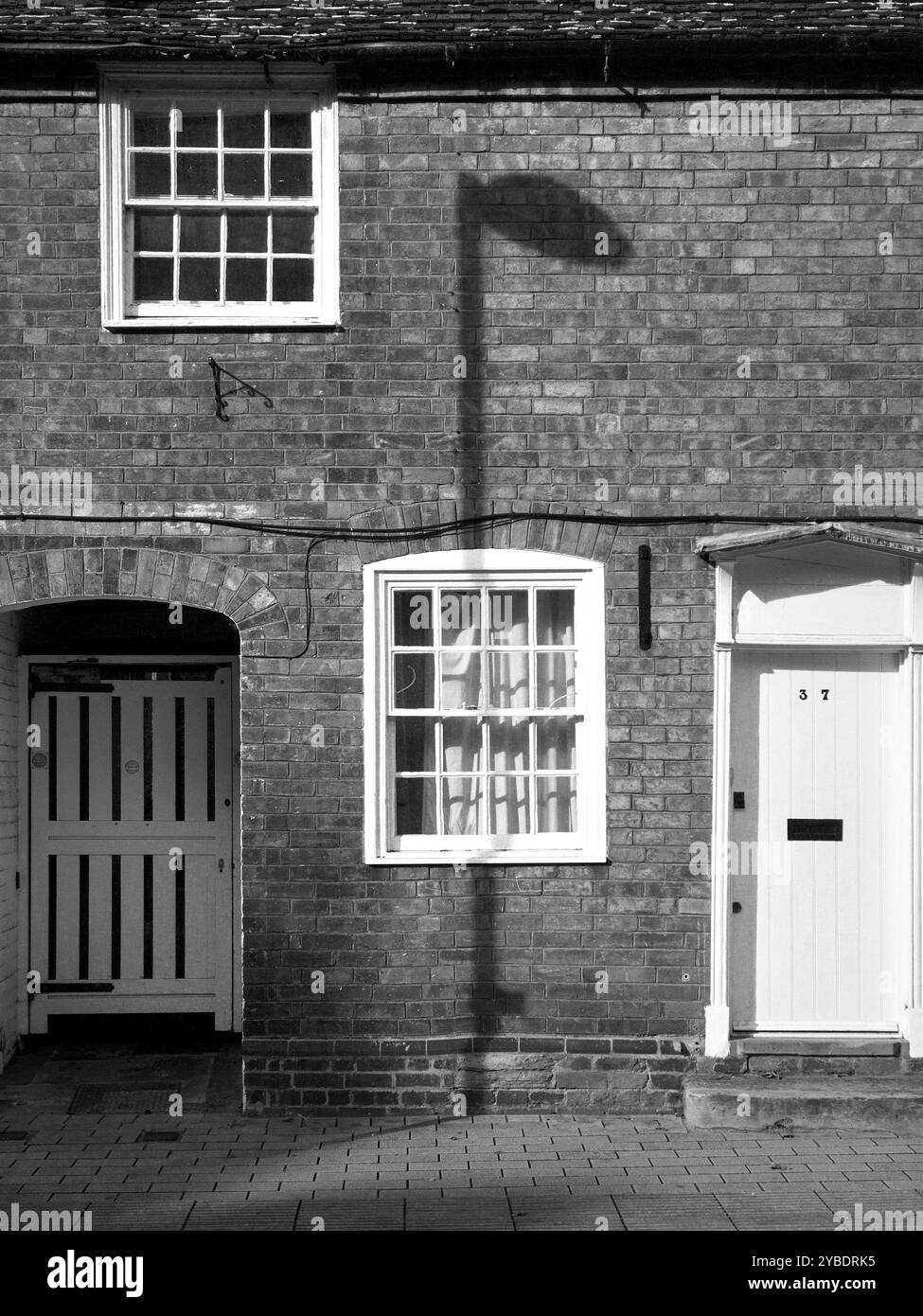 Ombre de lampadaire sur un mur de cottage. Stratford upon Avon, Angleterre, Royaume-Uni. Photographie noir et blanc Banque D'Images