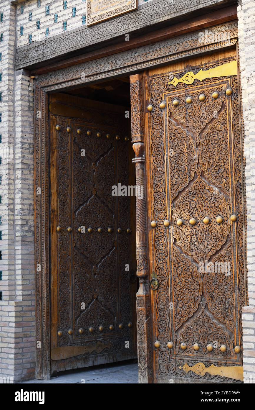 Entrée principale avec belle ancienne porte en bois sculpté avec poignée en métal massif. Palais Besh Khovli. Khiva, Ouzbékistan Banque D'Images