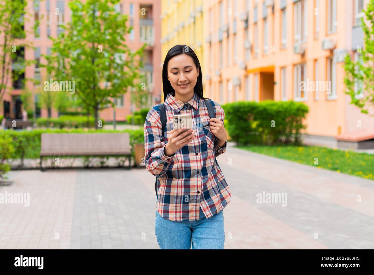 Femme asiatique coréenne parlant sur le téléphone portable avec un fond de bâtiment coloré Banque D'Images