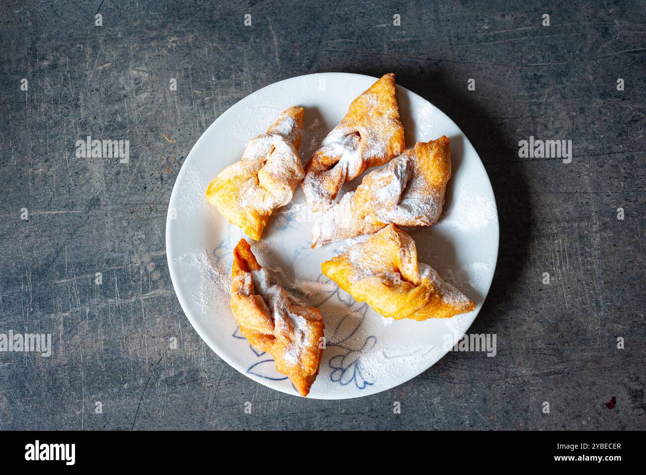 Pâtisserie sucrée croustillante hongroise nommée csöröge fánk (ailes d'ange) avec du sucre en poudre sur une assiette. Banque D'Images