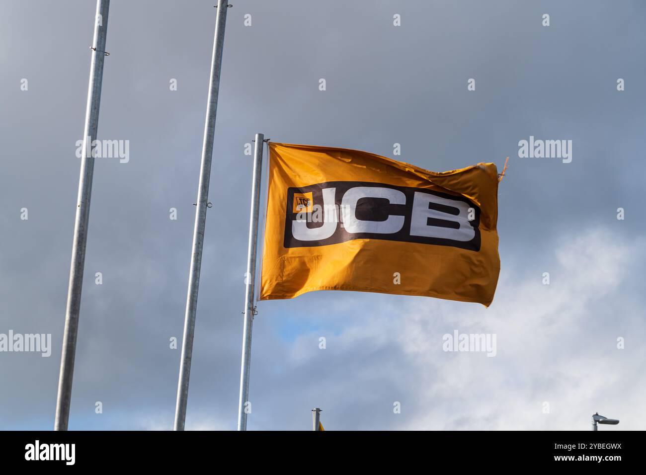Newport, Shropshire, Royaume-Uni – 17 octobre 2024 : drapeau flottant avec le logo de la société de fabricant de machines de construction, JCB Banque D'Images