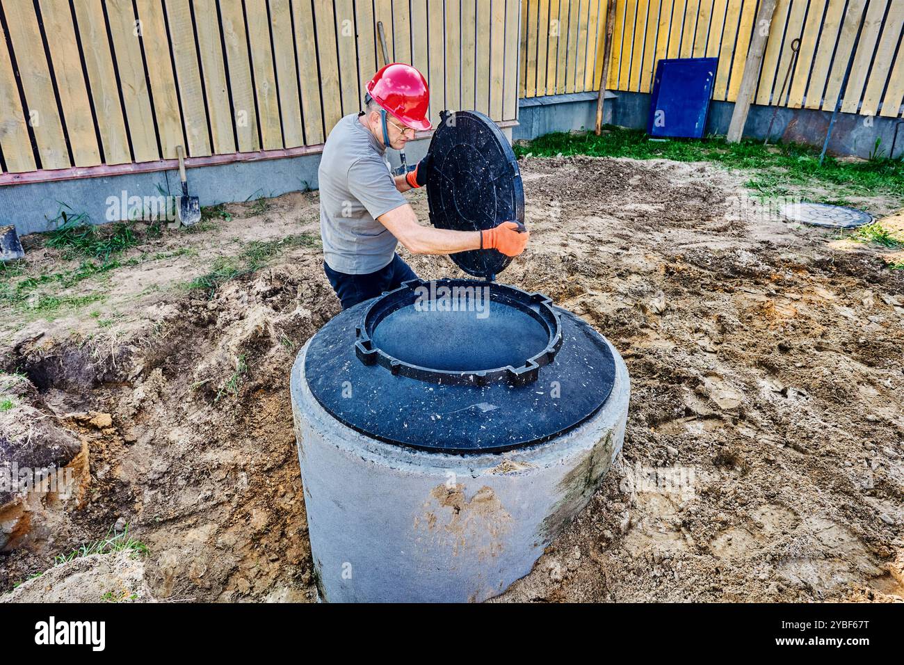 Constructeur porte couvercle de trou d'homme pour couvrir bien fait d'anneaux de béton. Banque D'Images