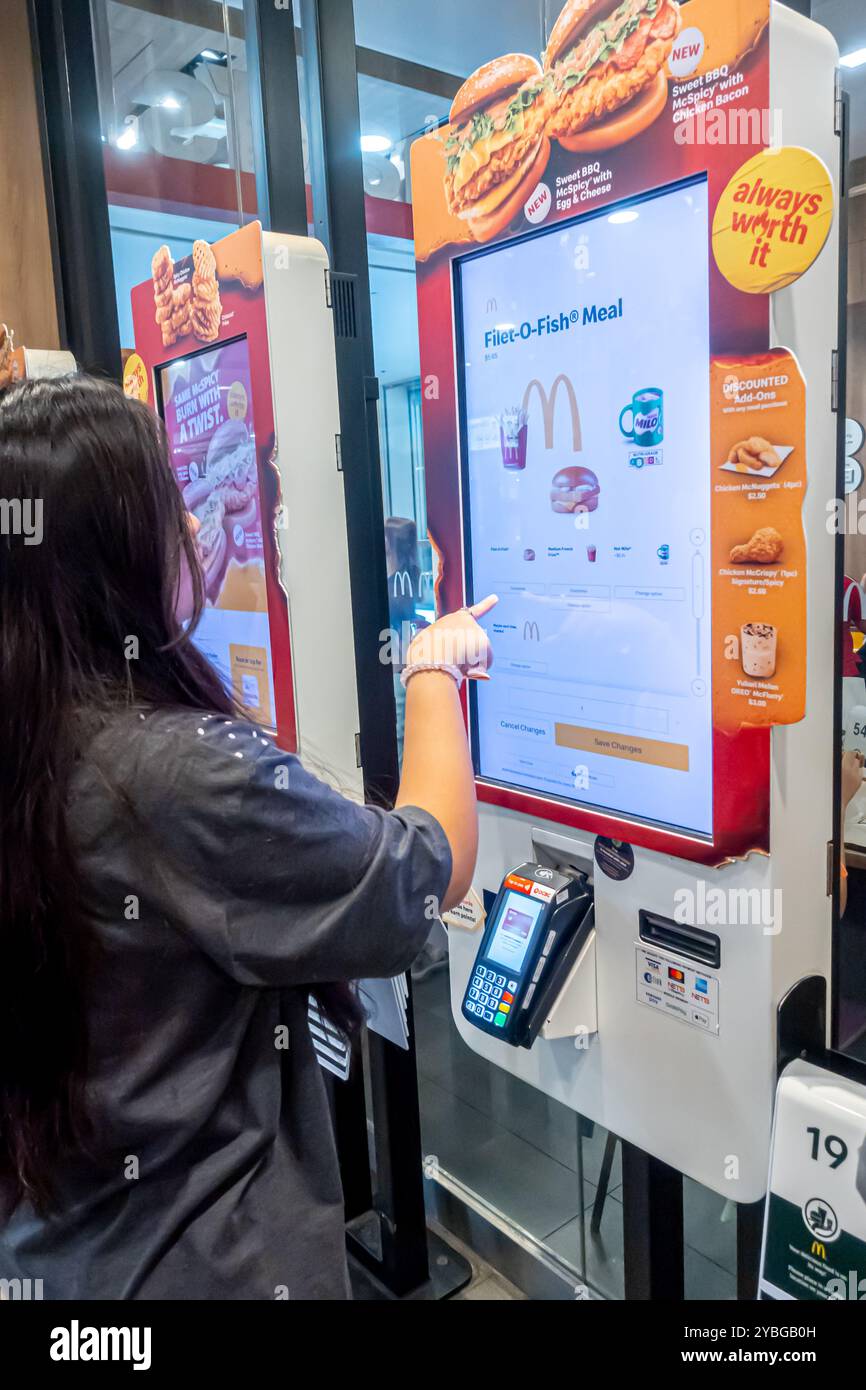 Femme commandant un repas filet-o-fish dans le terminal à écran tactile McDonald's Tiong Bahru Singapour Banque D'Images