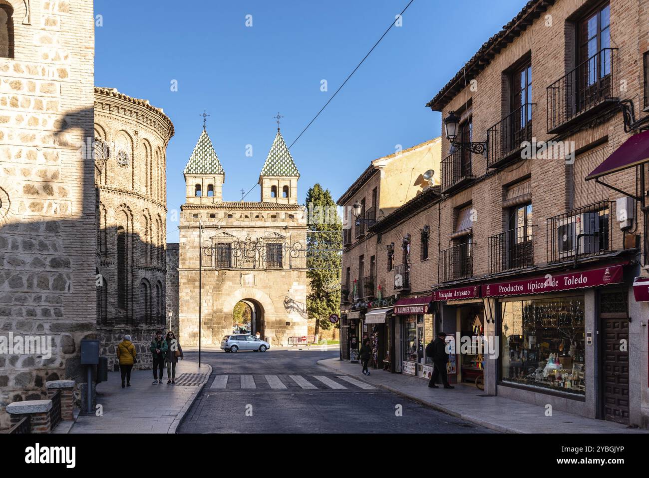 Tolède, Espagne, 6 décembre 2019 : Nouvelle porte de Bisagra et église Santiago del Arrabal. Rue Real del Arrabal, Europe Banque D'Images