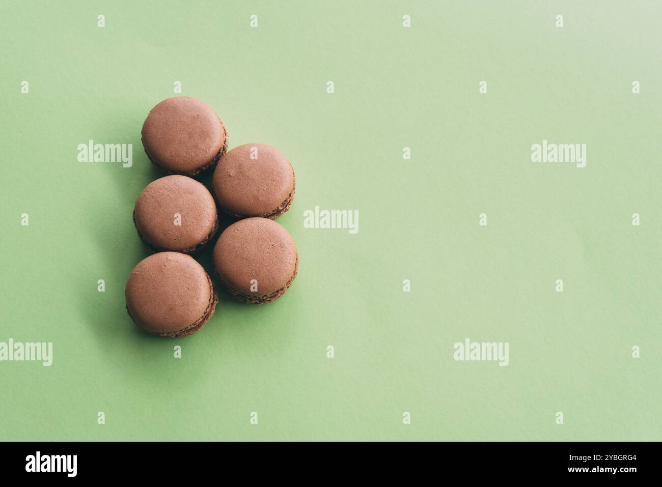 Pose plate de macarons sur fond vert Banque D'Images