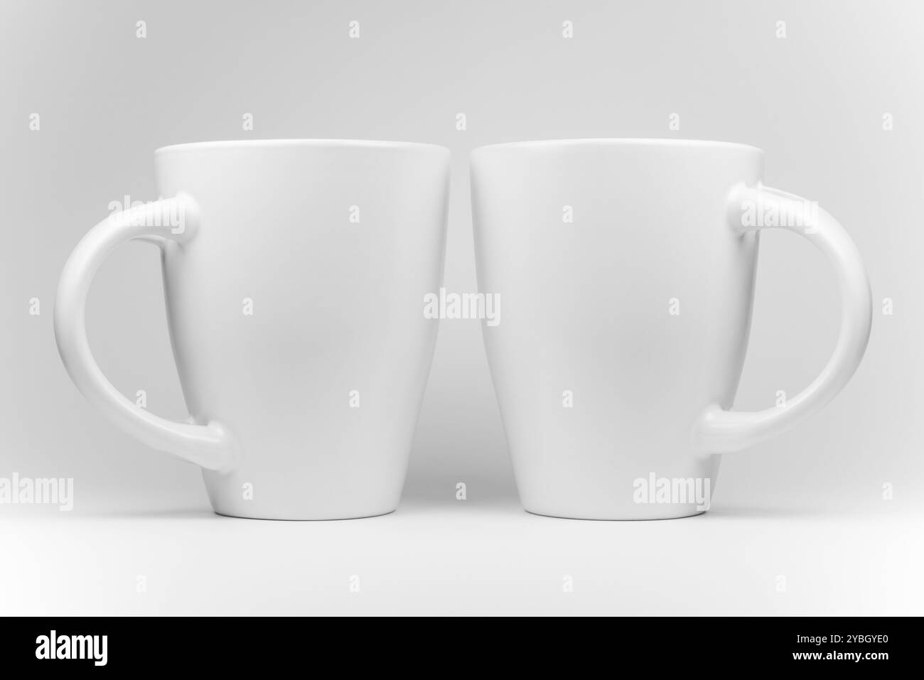 Deux tasses blanches dans un arrangement en miroir en high-key Banque D'Images