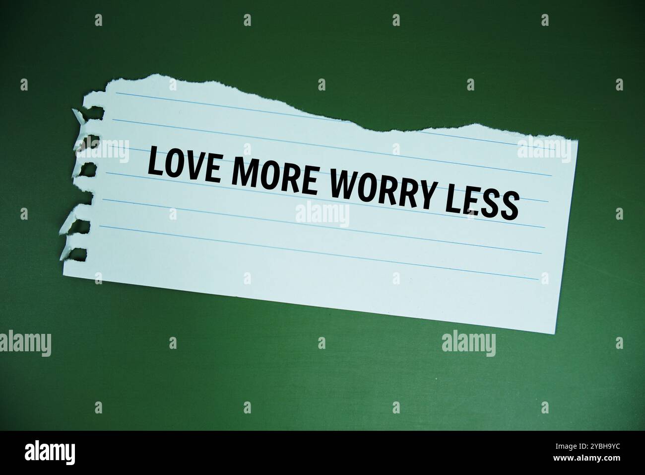 Love More Worry Less texte écrit sur papier déchiré vue de dessus sur fond vert Banque D'Images