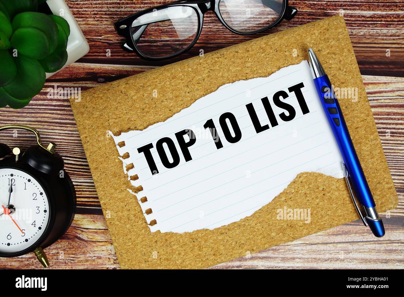 Top 10 liste texte écrit sur papier déchiré avec stylo vue de dessus sur fond de bois Banque D'Images