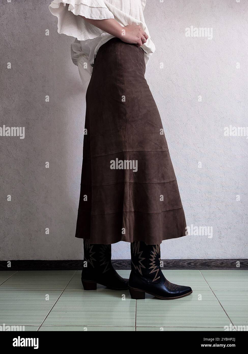 Tenue rétro, jupe en cuir de daim fin authentique Vintage, bottes cosaques de cowboy, Blouse bohème blanche, vue avant, Détails de la tenue, femme anonyme, Brown A Line Boho Patchwork jupe midi, jupe café Banque D'Images