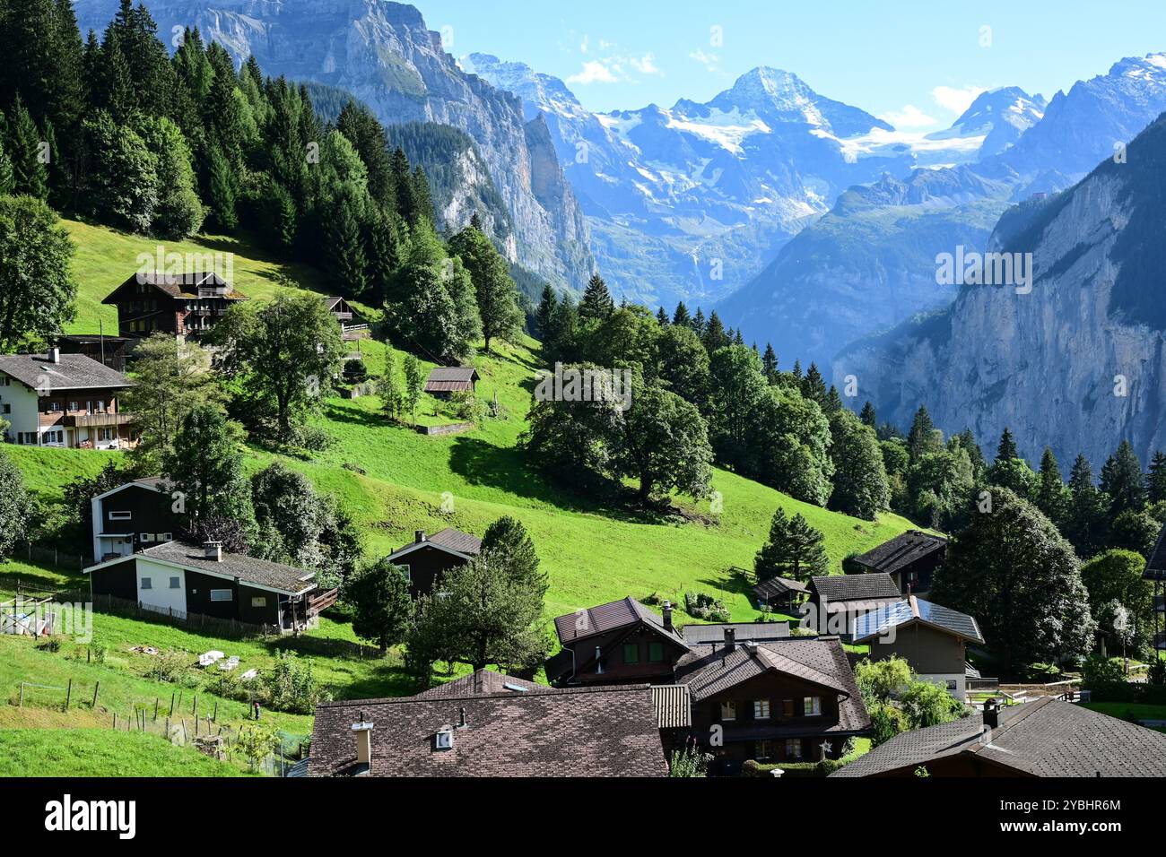Chalets à flanc de colline près du village de Wengen au-dessus de la vallée de Lauterbrunnen avec le pic de montagne Breithorn (horizon central) dans les Alpes bernoises, SWI Banque D'Images