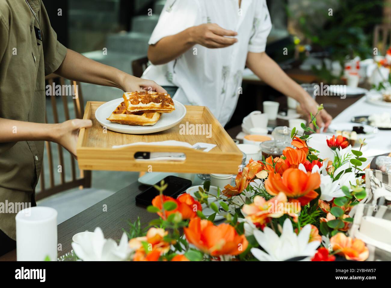 Serveuse servant des gaufres belges au client au café. Banque D'Images