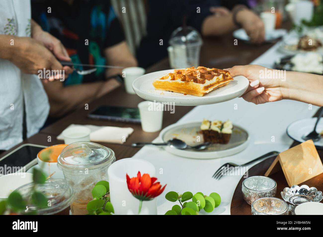 Serveuse servant des gaufres belges au client au café. Banque D'Images