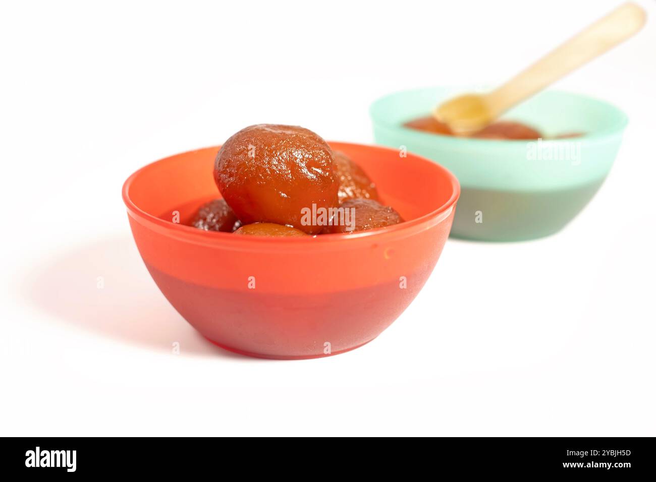 Deux bols colorés remplis de gulab jamun dessert sur fond blanc. Banque D'Images