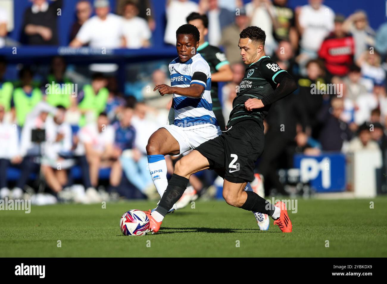 Jordan Williams de Portsmouth se bat pour le ballon contre Karamoko Dembele des Queens Park Rangers lors du Sky Bet Championship match au MATRADE Loftus Road Stadium de Londres. Date de la photo : samedi 19 octobre 2024. Banque D'Images