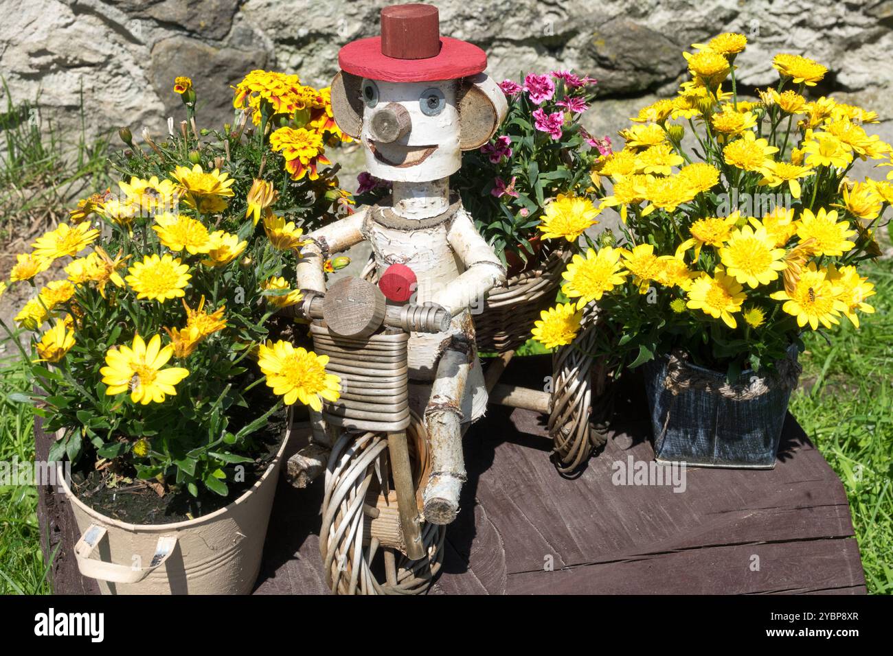 Les fleurs jaunes poussent dans des pots et jouet en bois dans le jardin Banque D'Images
