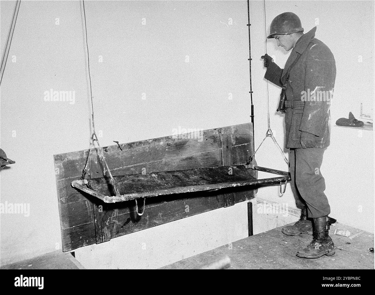 Un soldat américain teste l'ascenseur du crématorium lors d'une inspection du camp de concentration de Natzweiler-Struthof. Banque D'Images