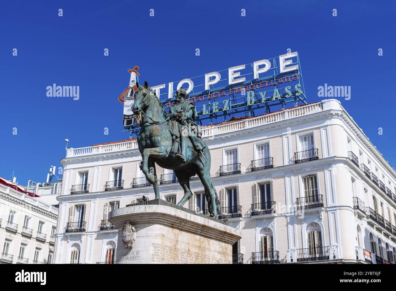 Madrid, Espagne, 8 mai 2021 : Puerta del sol dans le centre de Madrid. Statue équestre du roi Charles III contre le panneau emblématique de Tio Pepe le jour du ciel bleu ensoleillé Banque D'Images