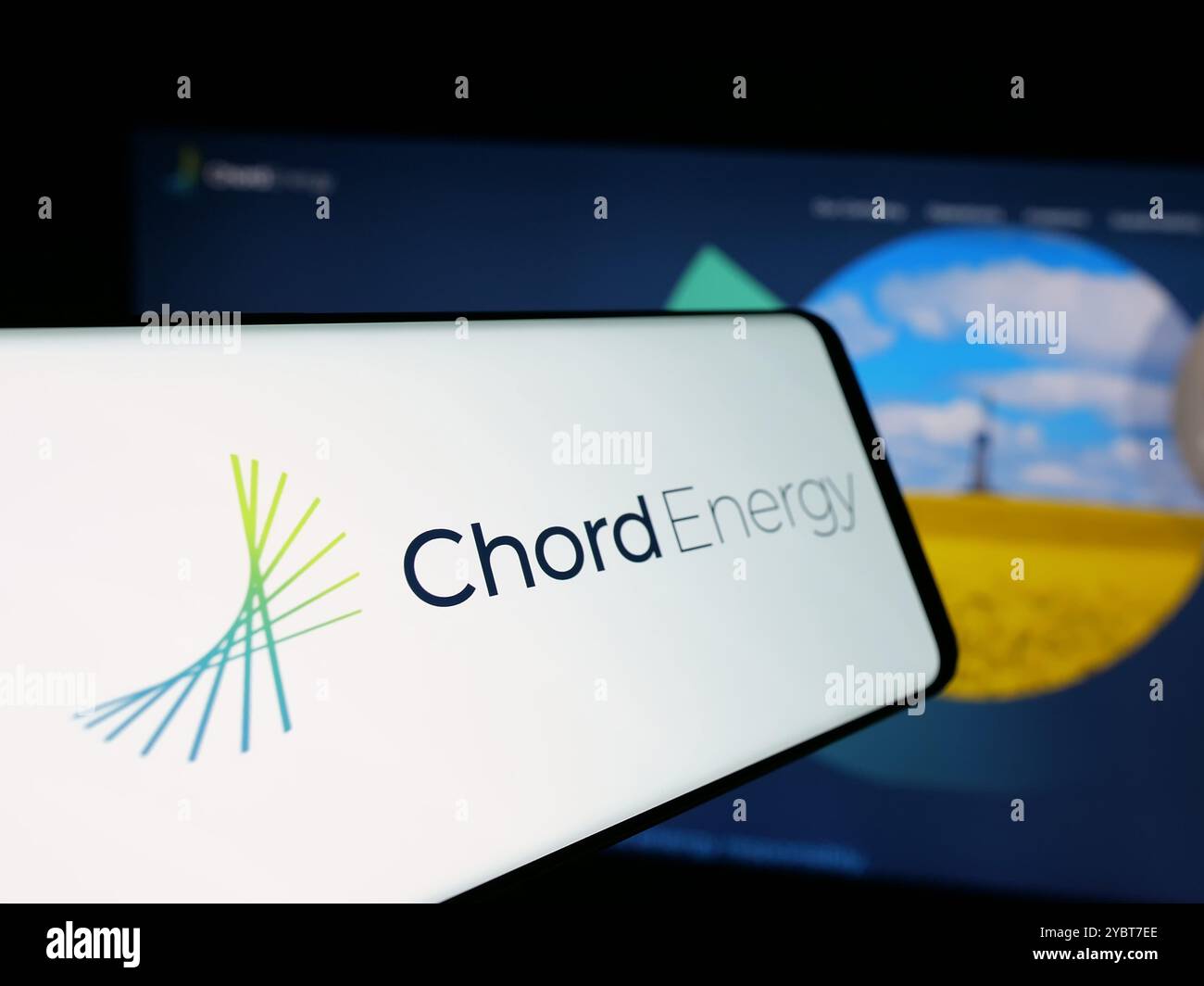 Téléphone portable avec logo de la société pétrolière américaine Chord Energy Corporation sur l'écran en face du site Web. Mettez l'accent sur le centre-gauche de l'écran du téléphone. Banque D'Images