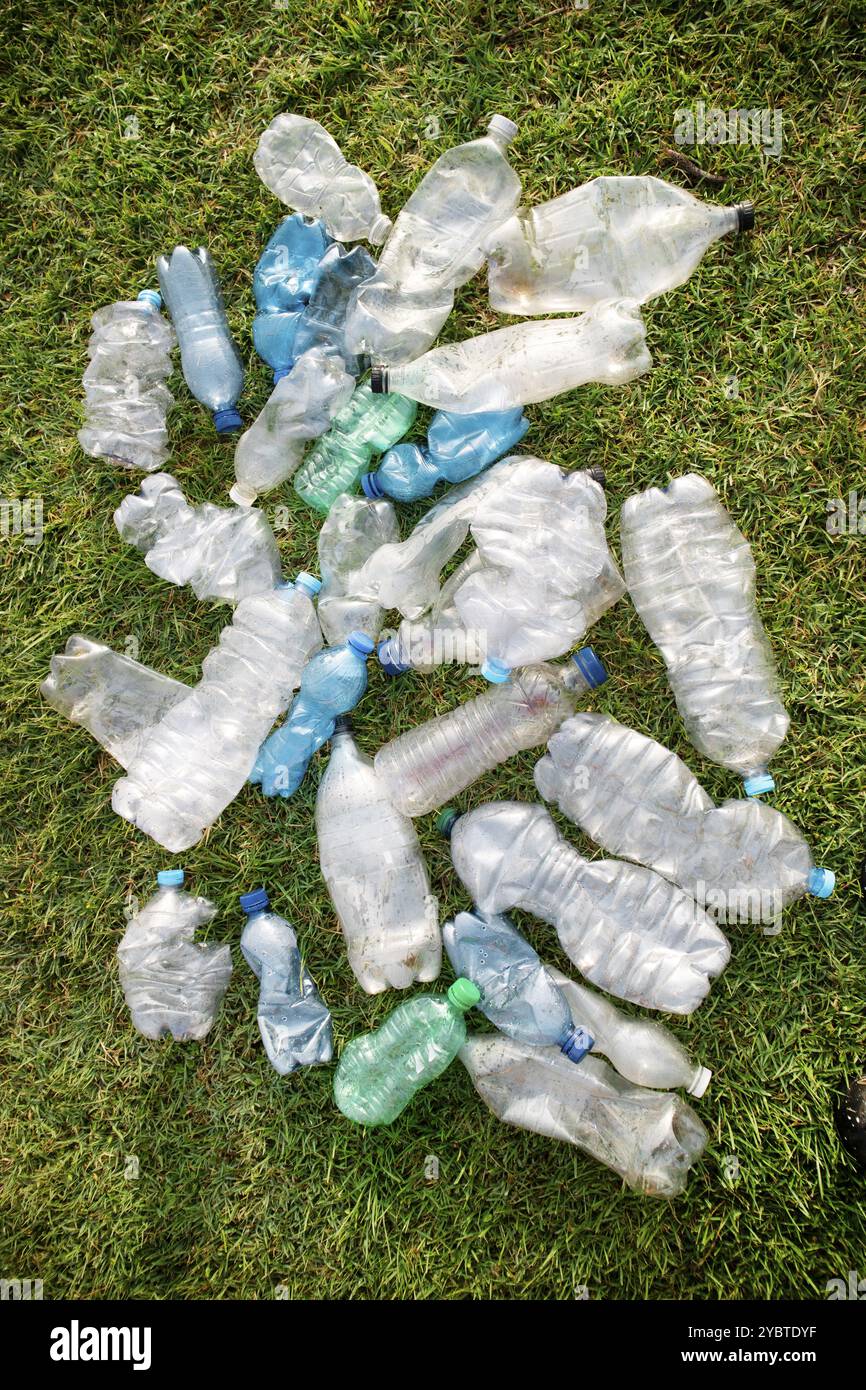 Signe d'incivilité utilisé bouteilles en plastique abandonnées dans un pré Banque D'Images