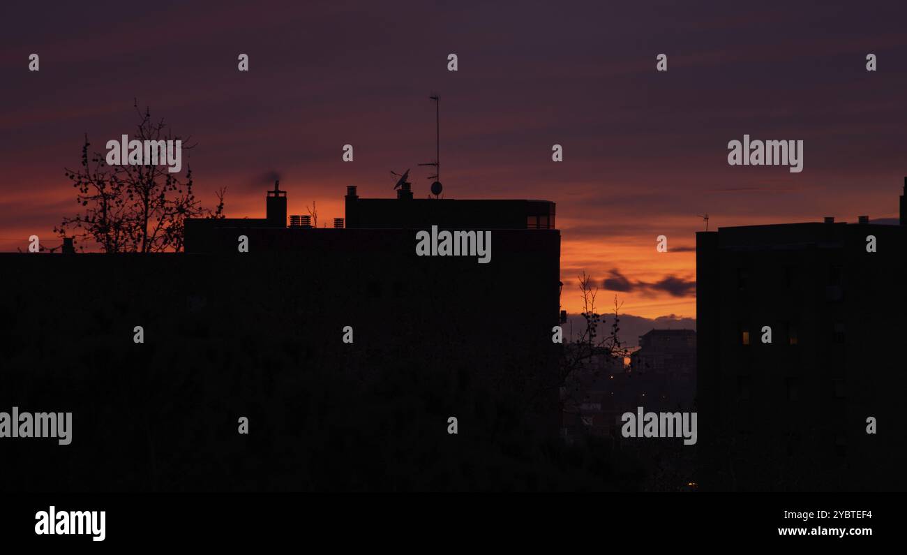 Coucher de soleil spectaculaire sur le paysage urbain. Concept de réchauffement climatique, silhouette Skyline Banque D'Images