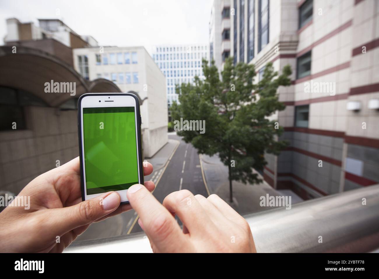 Point de vue d'un homme utilisant un smartphone avec un écran vert. Londres. Angleterre Banque D'Images