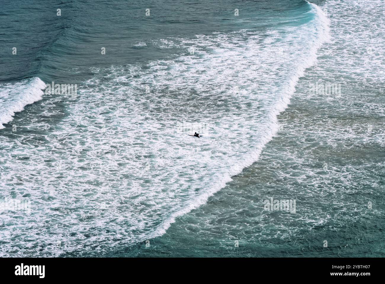 Vue aérienne des surfeurs surfant sur les vagues de la plage d'Antuerta à Ajo, Trasmiera, Cantabrie Banque D'Images