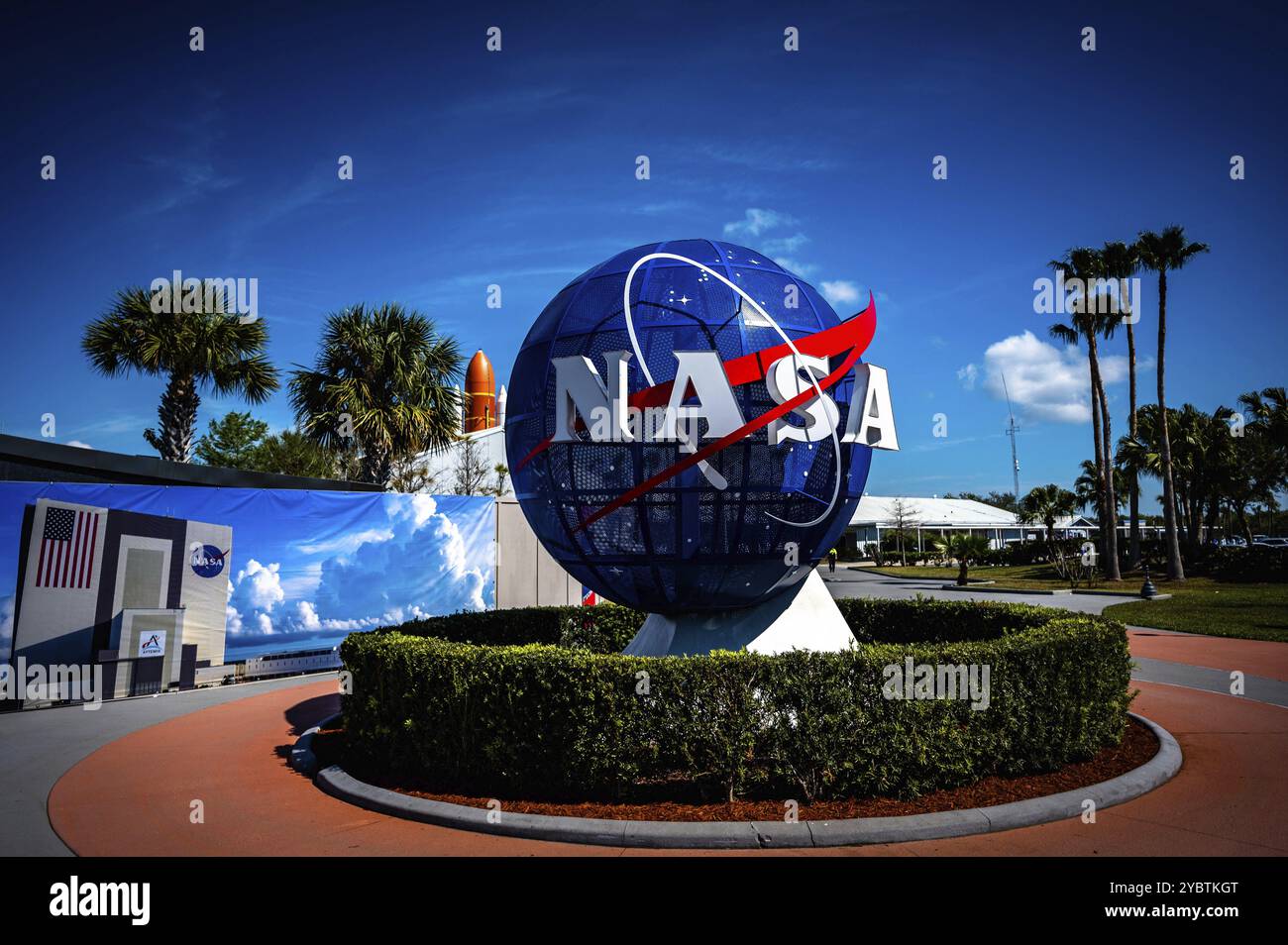 Logo de la NASA avec globe terrestre devant le ciel bleu et palmiers au Kennedy Space Center, Cape Canaveral Banque D'Images