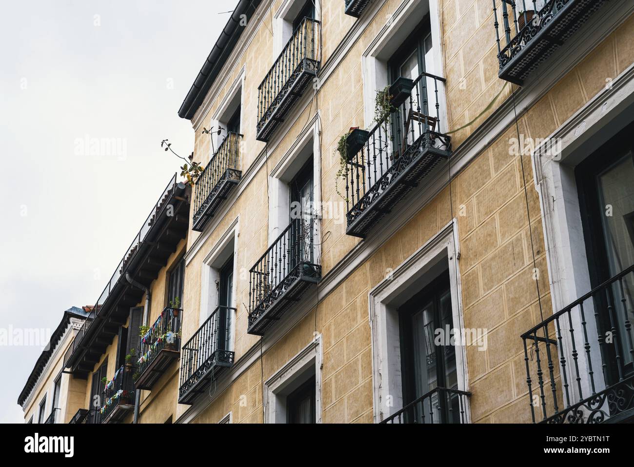 Vue à angle bas sur les balcons traditionnels en fonte de l'ancien Immeuble résidentiel dans le quartier Lavapies dans le centre de Madrid Banque D'Images