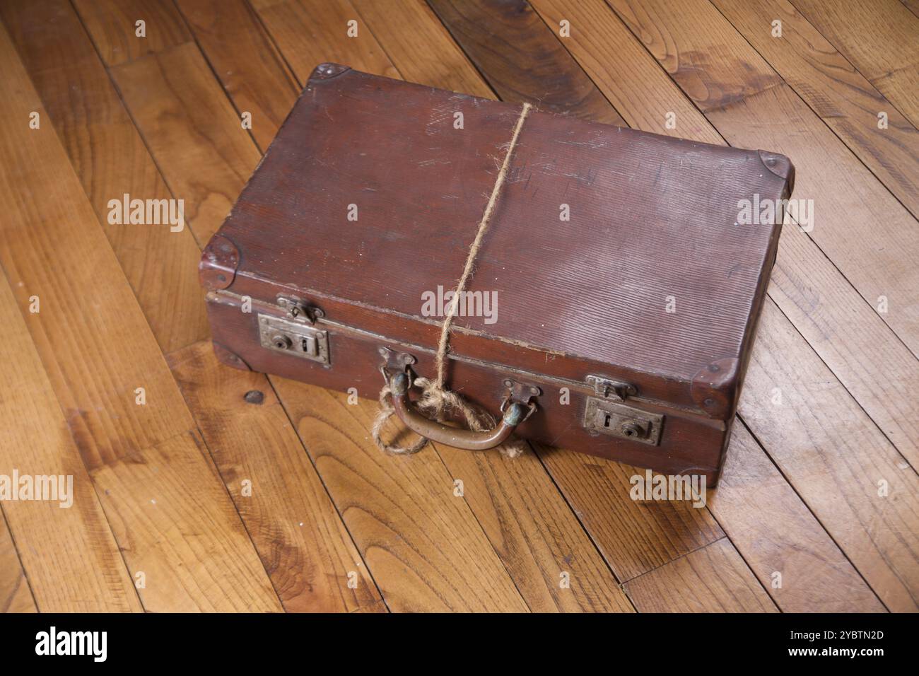 Ancienne valise en carton brun sur fond de plancher en bois Banque D'Images