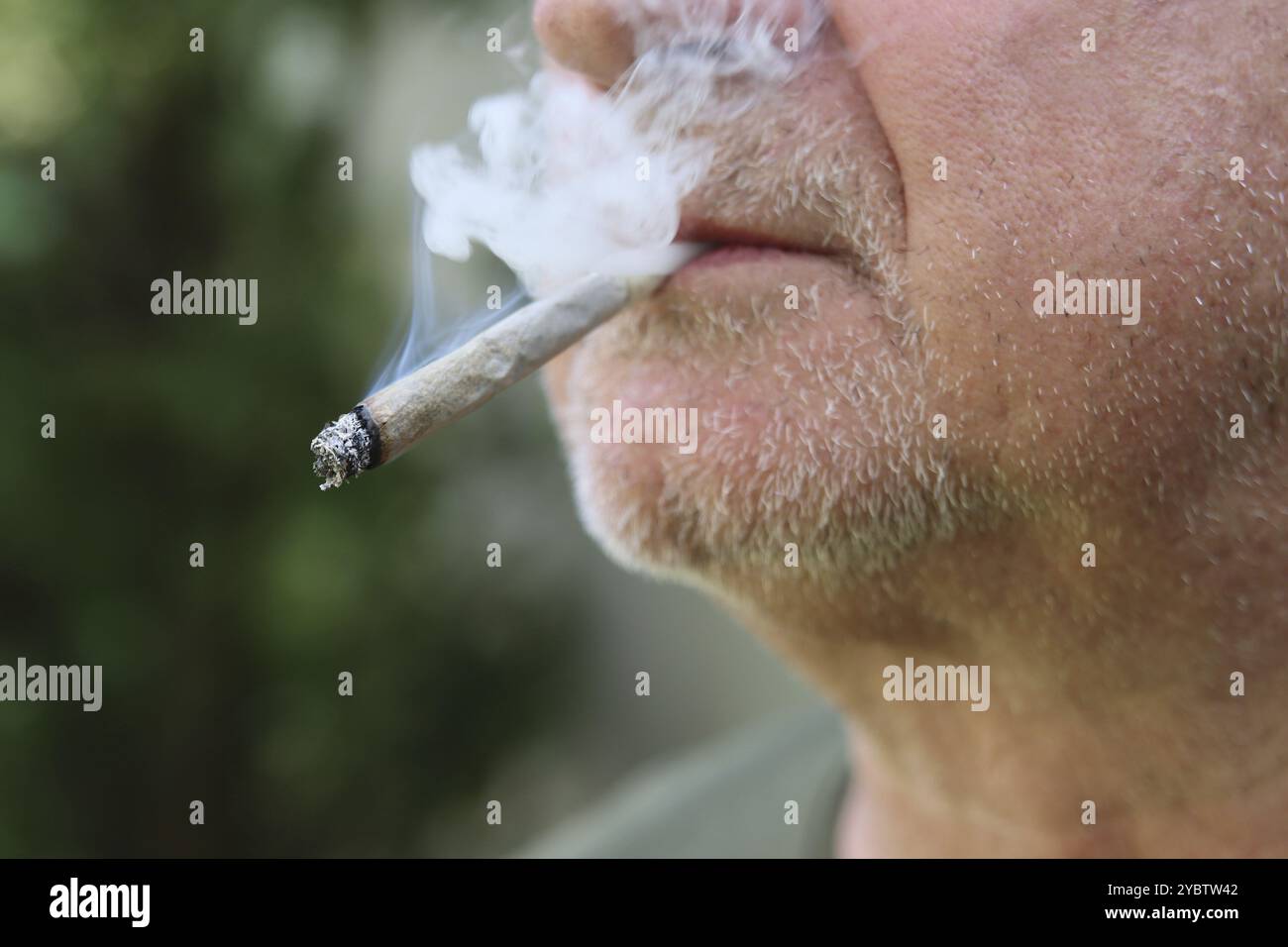 Un homme fume un joint Banque D'Images