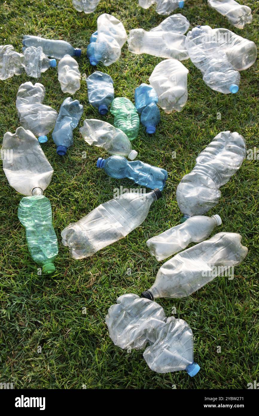 Signe d'incivilité utilisé bouteilles en plastique abandonnées dans un pré Banque D'Images