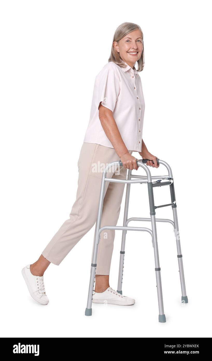 Femme senior utilisant le cadre de marche sur fond blanc Banque D'Images