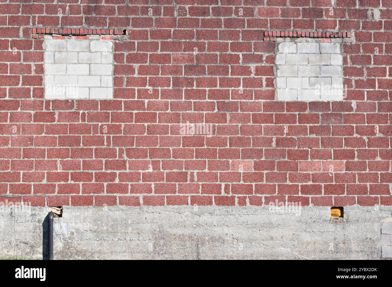 Mur extérieur de bâtiment en blocs avec deux fenêtres scellées Banque D'Images