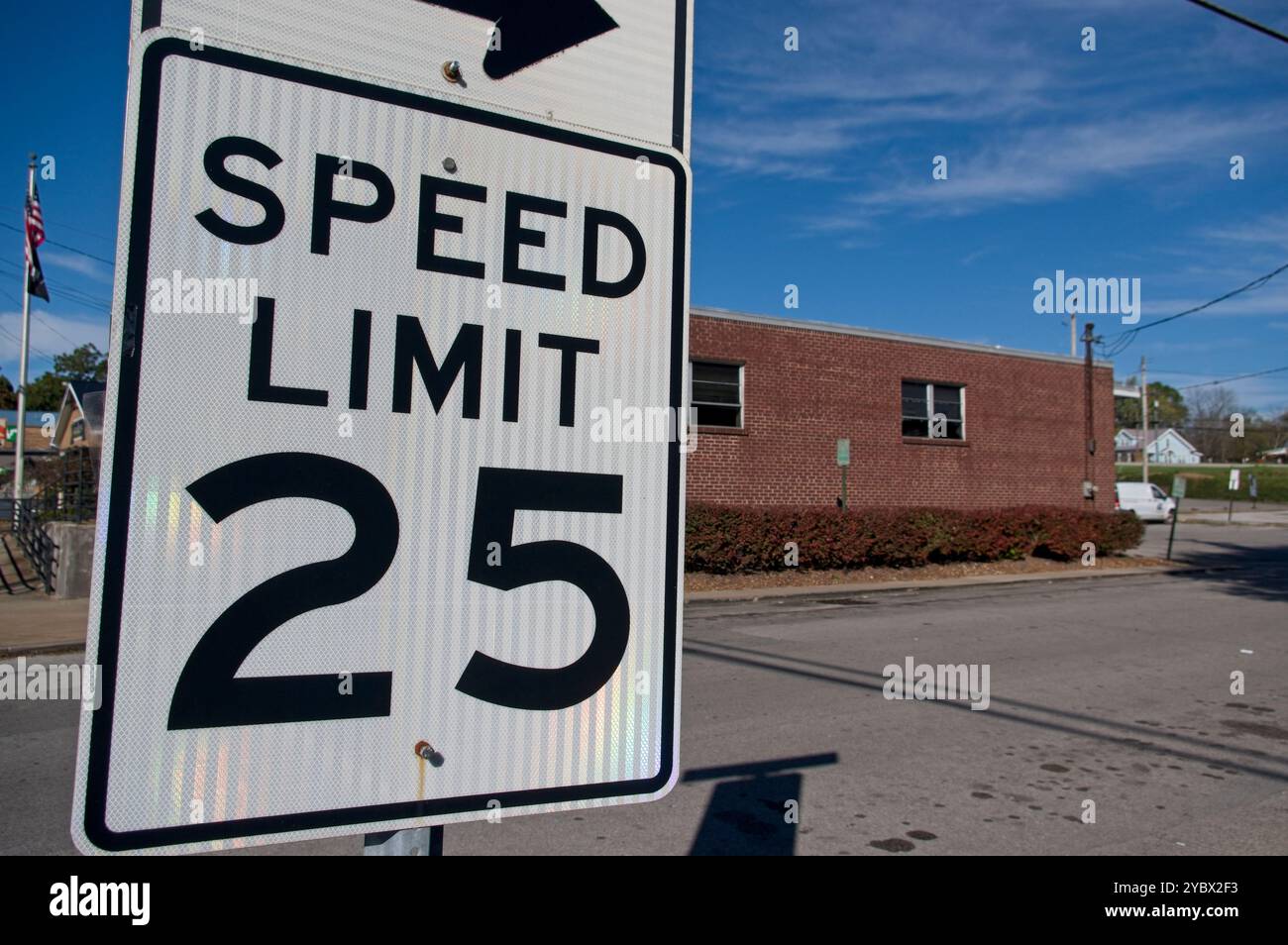 Panneau de limite de vitesse avec bâtiment de briques en arrière-plan Banque D'Images