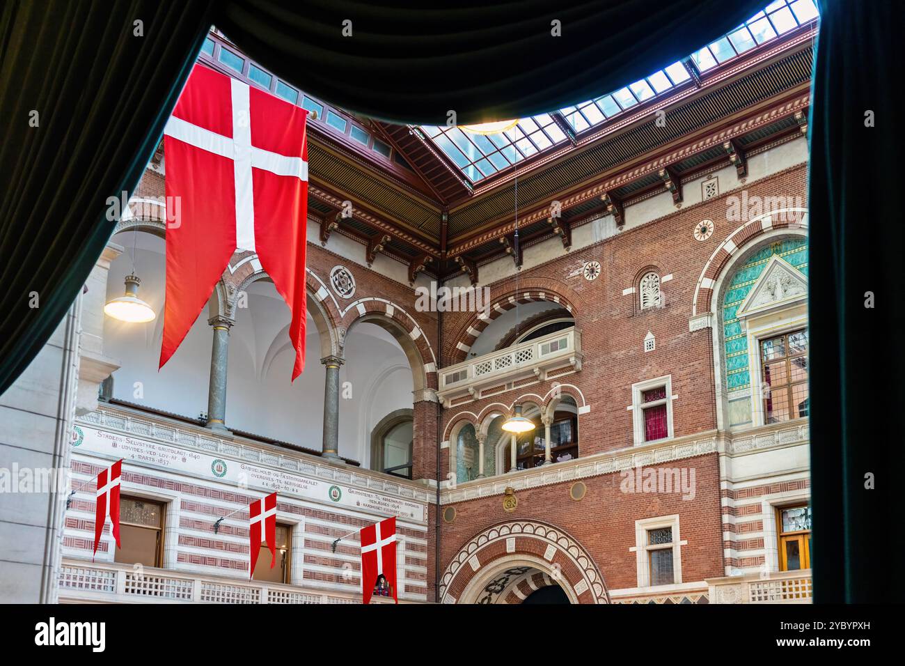 L'intérieur de l'hôtel de ville de Copenhague, au Danemark, orné de drapeaux danois, présente une architecture en briques époustouflante, des arches et des dessins détaillés. Banque D'Images