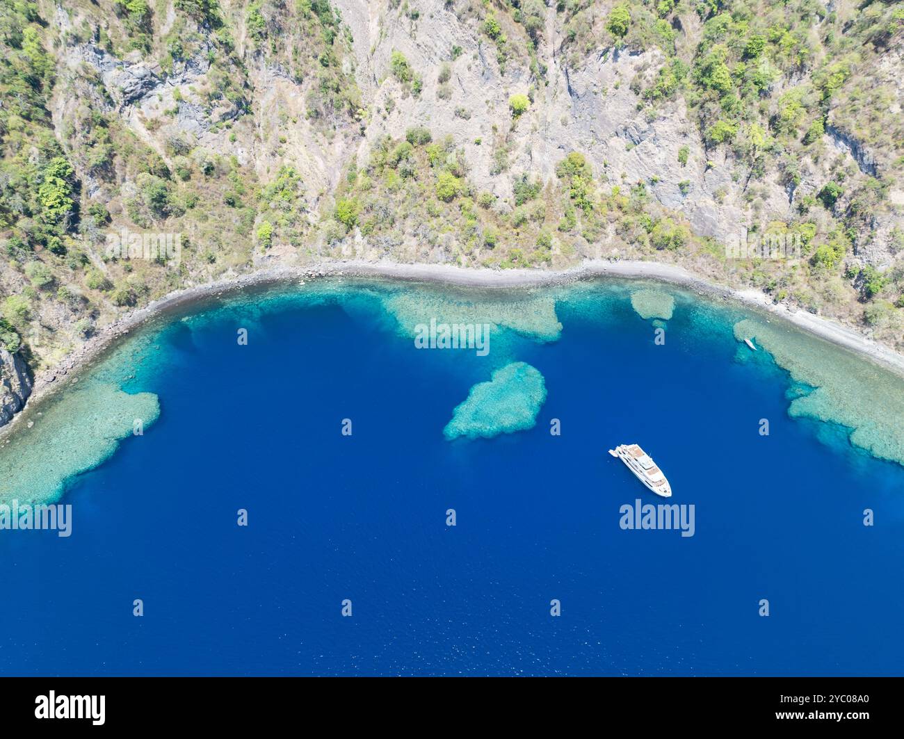 Entourée de récifs coralliens, la côte reculée et accidentée de l'île volcanique de Komba se trouve à 70 km au nord des petites îles Sunda d'Indonésie. Banque D'Images