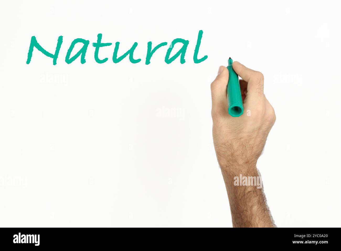 Un homme écrit 'Natural' sur un tableau blanc avec un marqueur vert. Espace pour le texte. Banque D'Images