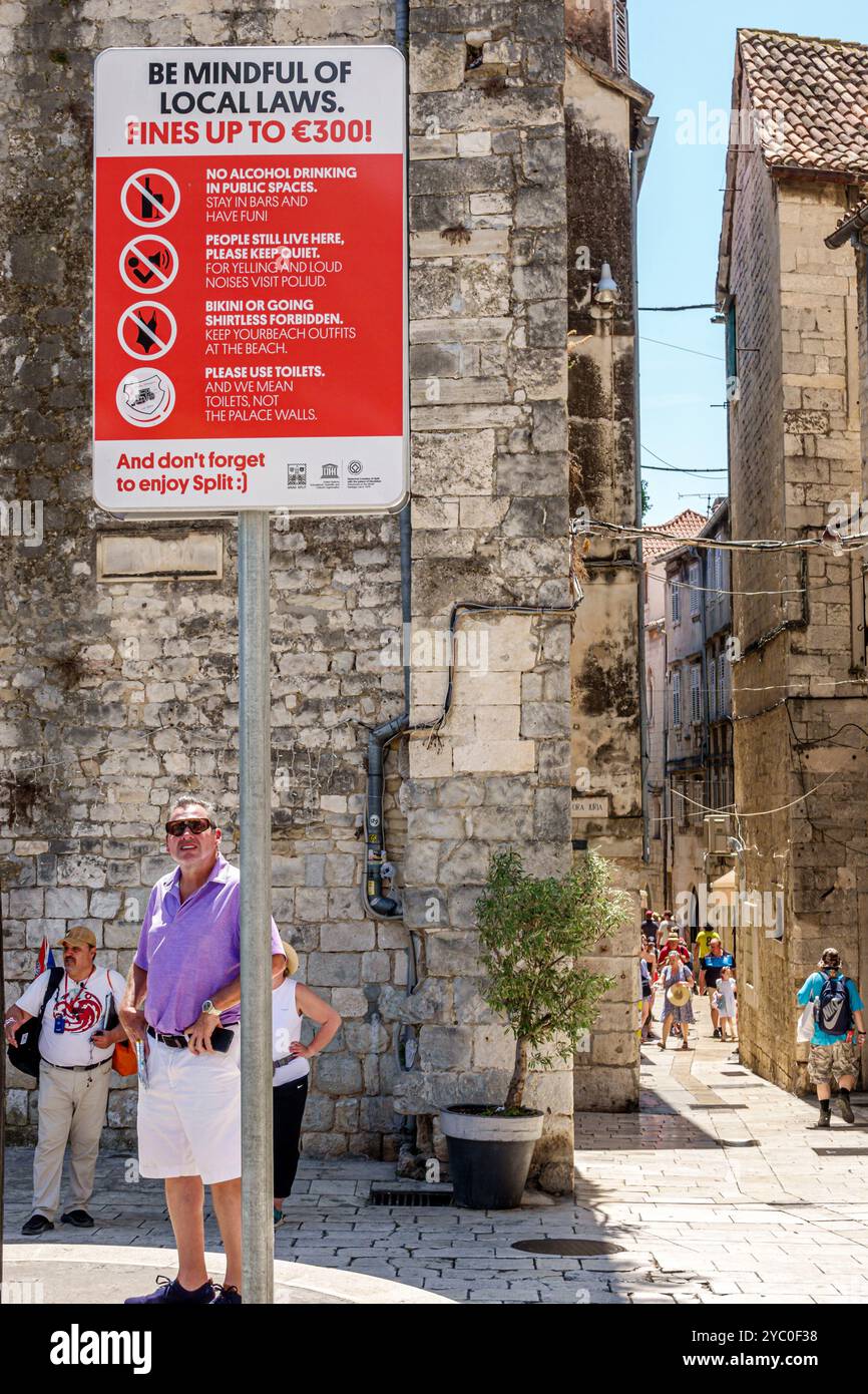 Split Croatie, vieille ville, signe d'avertissement, les lois locales amendes, être conscient, Dioclétien's Palais Dioklecijanova entrée palaca, rue étroite, homme touristique vi Banque D'Images