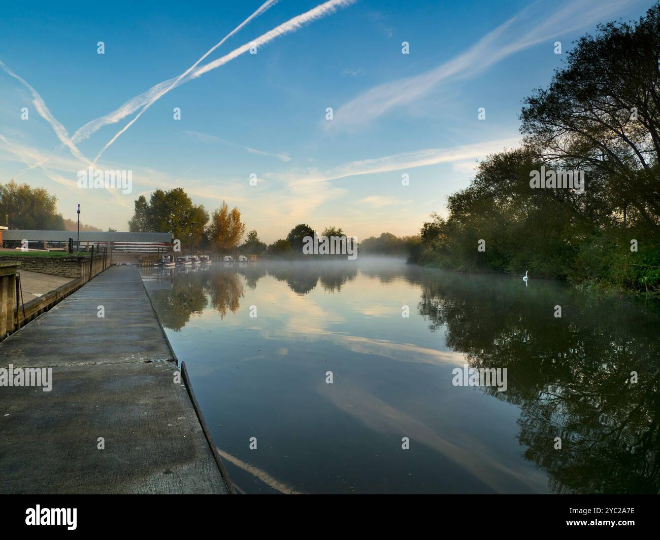 Lever du soleil sur une belle portion de la Tamise près de Radley Boathouse. Fondé en 1921, le hangar à bateaux sert le Radley College et les amateurs d'aviron locaux depuis plus d'un siècle. Si vous vous tenez sur sa jetée et regardez à travers la rive nord de la rivière, vous verrez cet arbre isolé et plutôt charmant, qui semble changer de caractère et d'apparence tout au long de l'année. Il peut être particulièrement beau au lever du soleil - comme ici. Banque D'Images