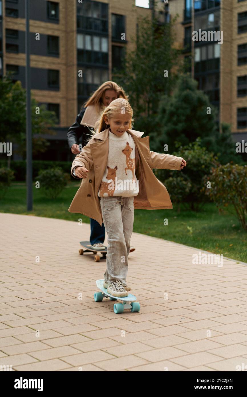 Maman et fille skateboard dans un parc de la ville Banque D'Images