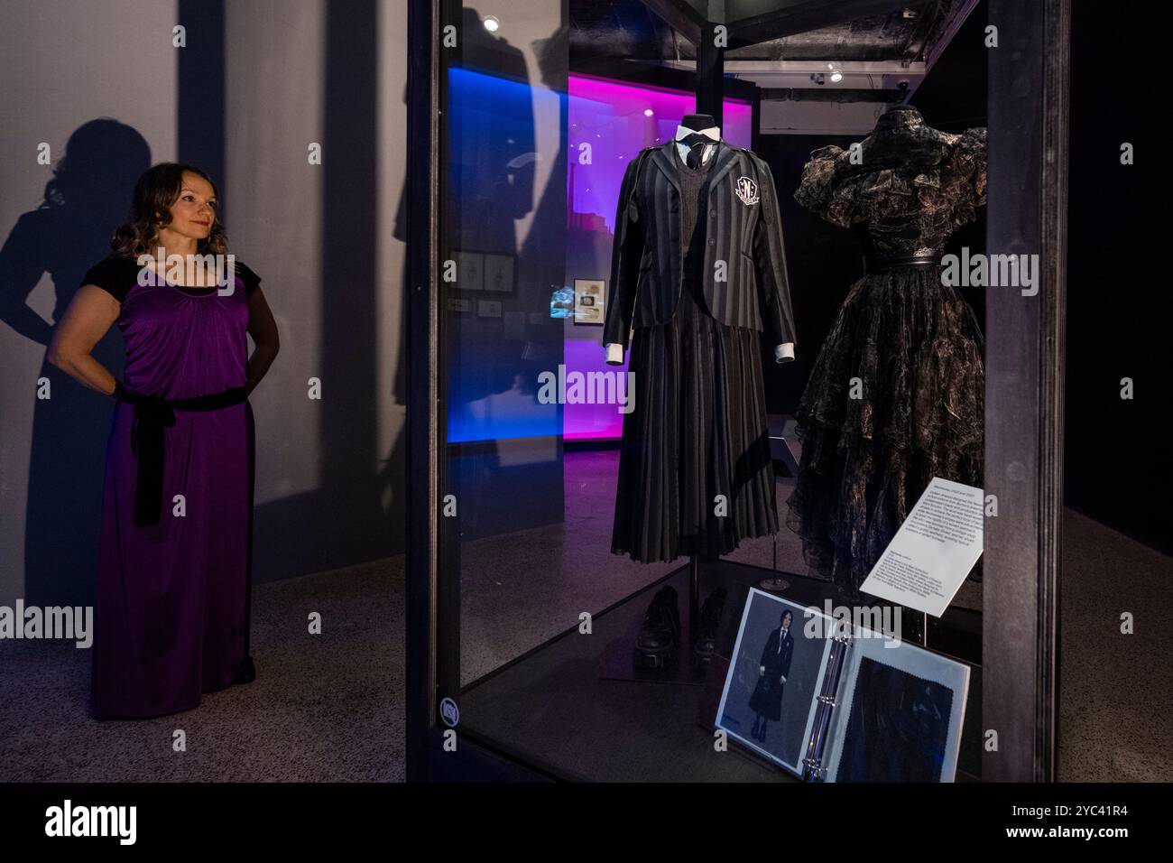 Londres, Royaume-Uni. 21 octobre 2024. Un membre du personnel voit l'uniforme de l'école Nevermore de la créatrice de costumes Colleen Atwood pour le film « mercredi », 2022 et 2025, lors d'une avant-première de l'exposition World of Tim Burton au Design Museum. Surtout connu pour son travail cinématographique, Tim Burton est aussi un artiste pluridisciplinaire à part entière. 600 articles de ses archives personnelles, couvrant 50 ans, sont exposés au Royaume-Uni pour la première fois, du 25 octobre 2024 au 21 avril 2025. Credit : Stephen Chung / Alamy Live News Banque D'Images