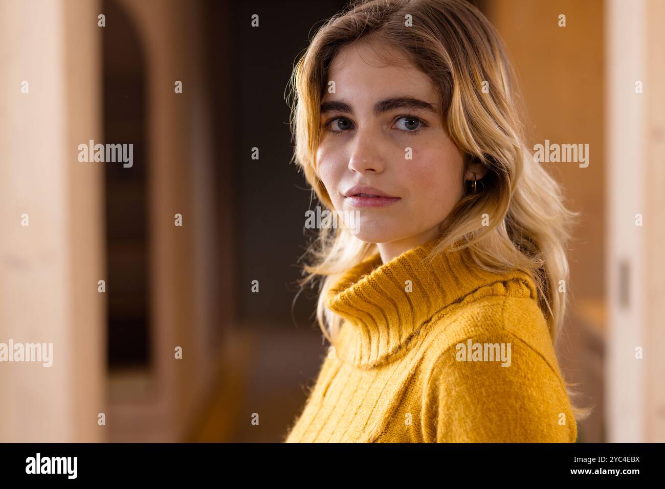 Femme en pull confortable souriant chaleureusement à la maison pendant la saison de Noël, espace de copie Banque D'Images
