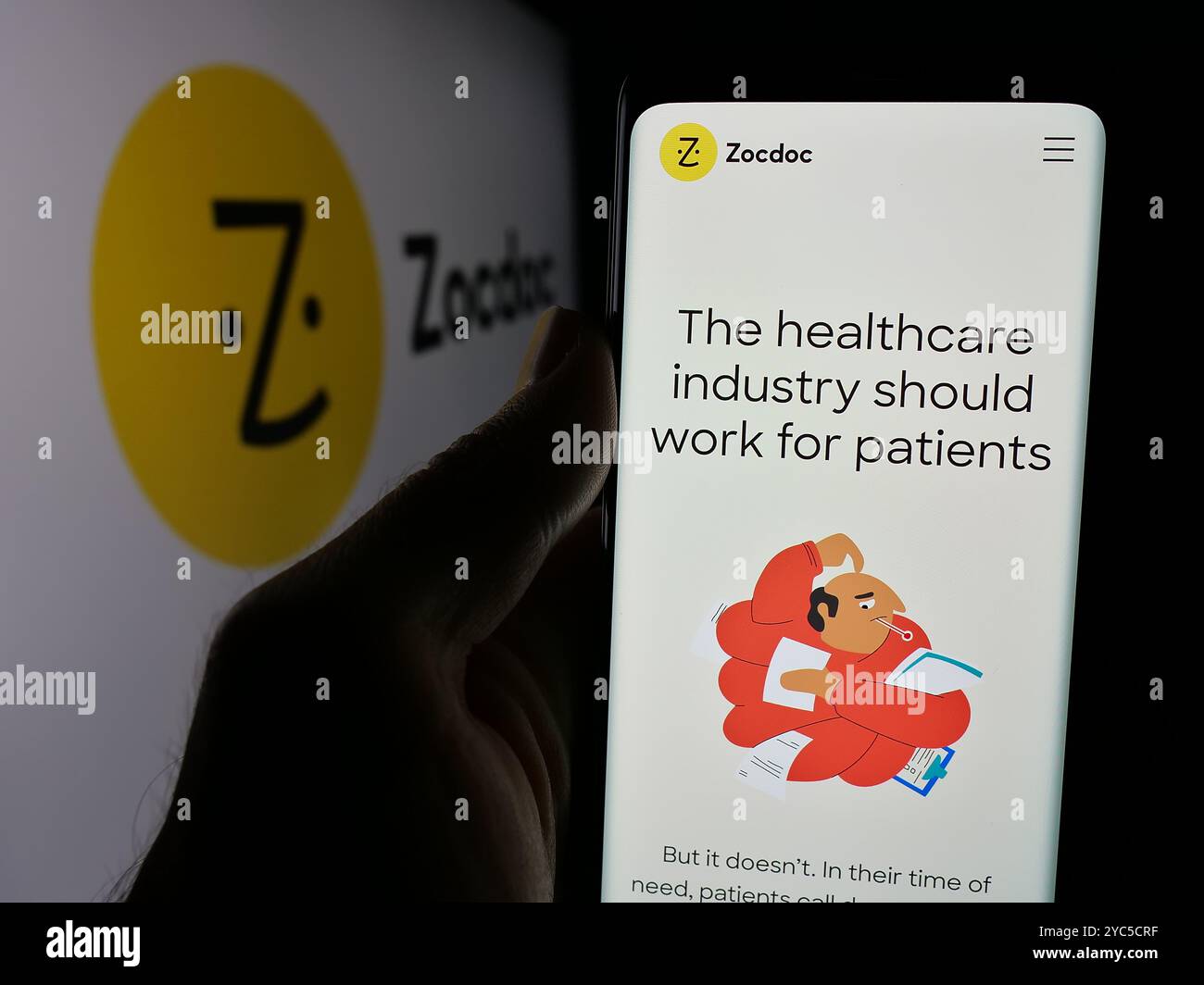 Personne tenant le téléphone portable avec la page Web de la société américaine de télémédecine Zocdoc Inc sur l'écran devant le logo. Concentrez-vous sur le centre de l'écran du téléphone. Banque D'Images