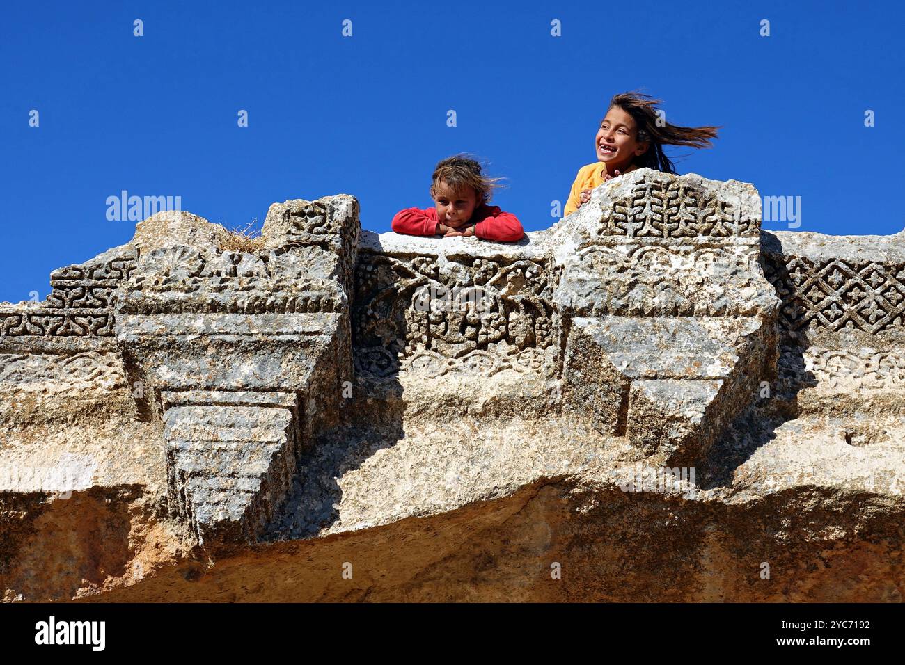 Sanliurfa, Turquie. 19 octobre 2024. On voit deux filles jouer sur les inscriptions du monument dans la cour arrière du temple assyrien. Dans le village de Buyuk Senem, à environ 70 kilomètres de la ville de Sanliurfa dans le sud-est de la Turquie, les anciennes grottes de Senem dans la même zone que le magnifique temple syriaque de 3 étages datant du Ve siècle après J.-C. sont utilisées par les villageois comme maisons et abris pour animaux. (Crédit image : © Mehmet Masum Suer/SOPA images via ZUMA Press Wire) USAGE ÉDITORIAL SEULEMENT! Non destiné à UN USAGE commercial ! Banque D'Images