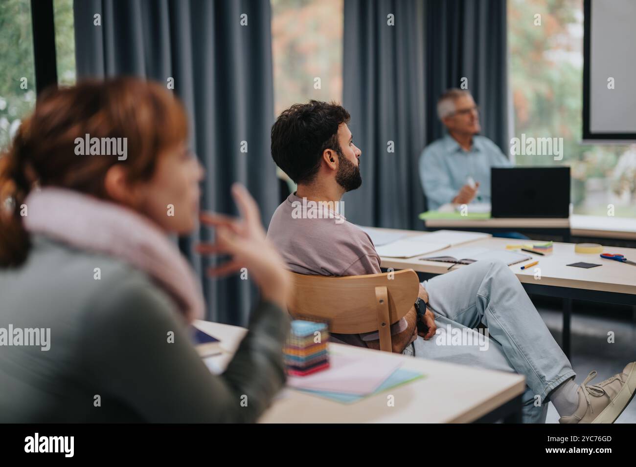 Les étudiants écoutent attentivement le professeur âgé en classe Banque D'Images
