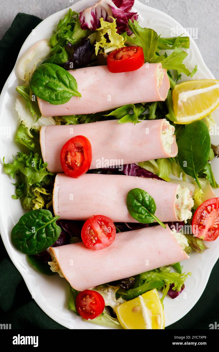 Snack rouleaux de jambon avec avocat et fromage à la crème pour un petit déjeuner. mise au point sélective Banque D'Images