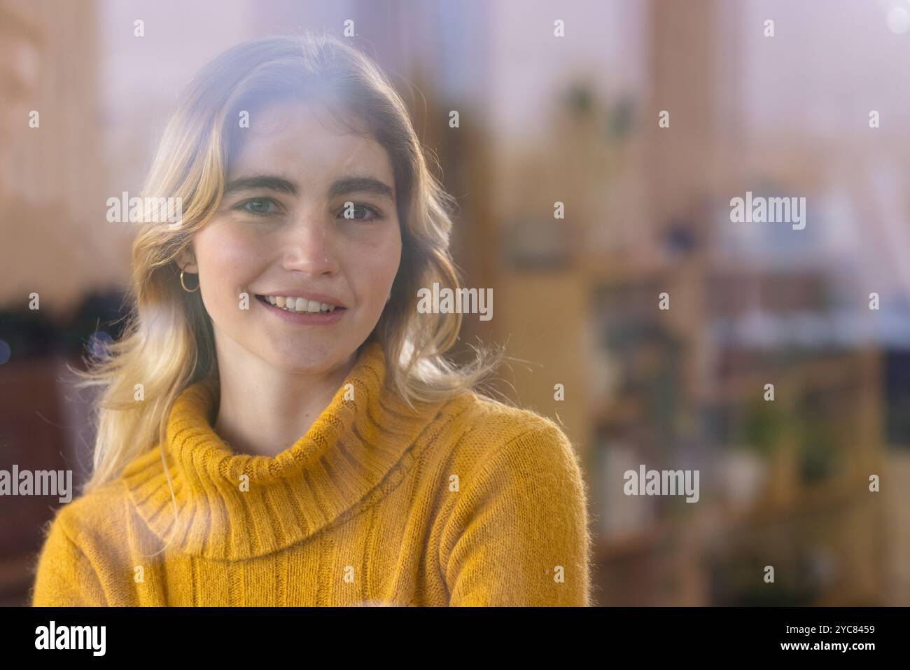 Femme souriante dans un pull confortable profitant d'une atmosphère de vacances chaleureuse à la maison, espace de copie Banque D'Images