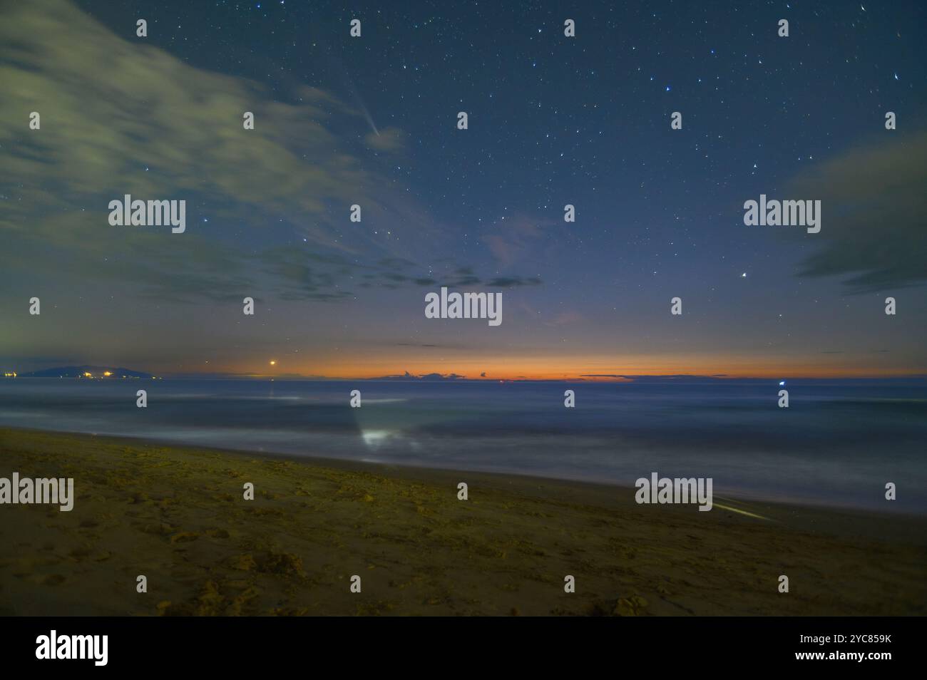 Le coucher de soleil côtier se transforme en une nuit étoilée. Dans la comète céleste C/2023 A3 (ATLAS de Tsuchinshan), étoiles et nuages, San Vincenzo, Italie Banque D'Images